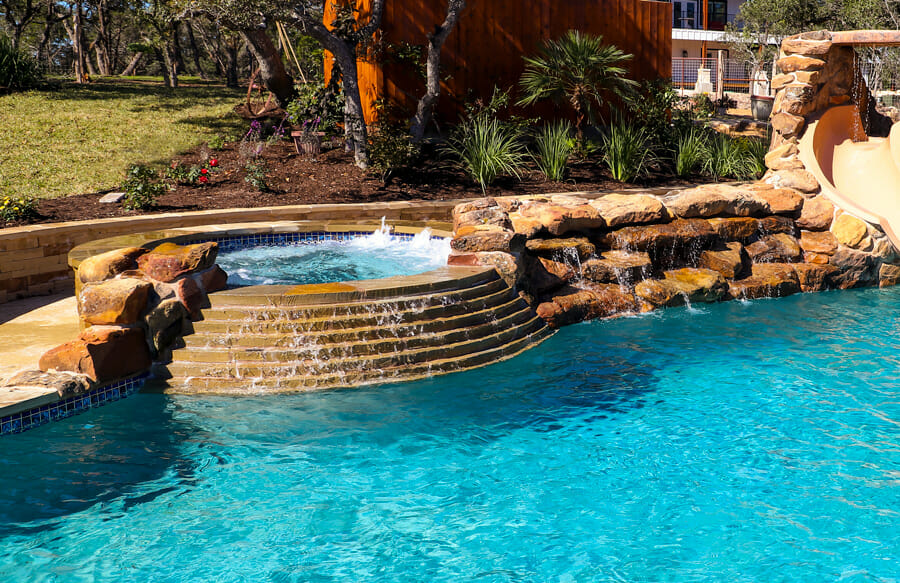 inground pool with rock waterfall