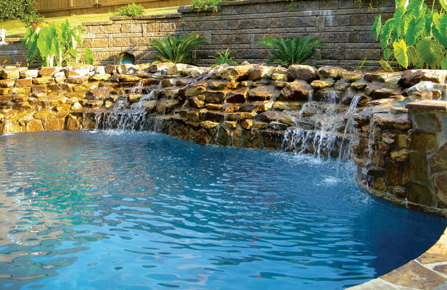 inground pool with rock waterfall