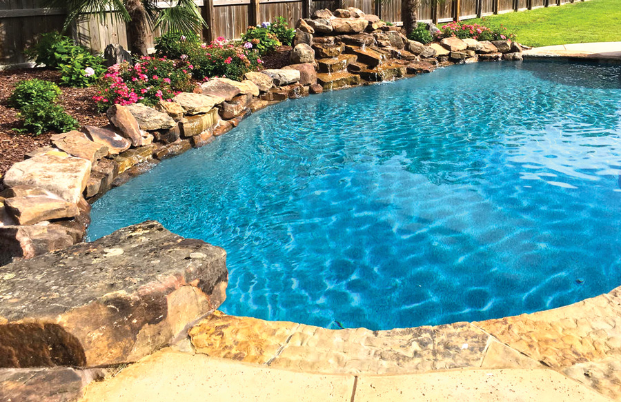 Tropical backyard pool with natural accent boulders and jump rock