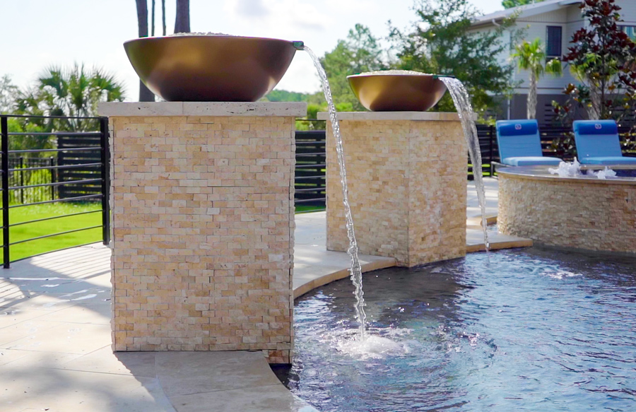 Copper water bowls spilling into pool