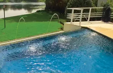 rectangular pool with deck jets creating arcing water streams