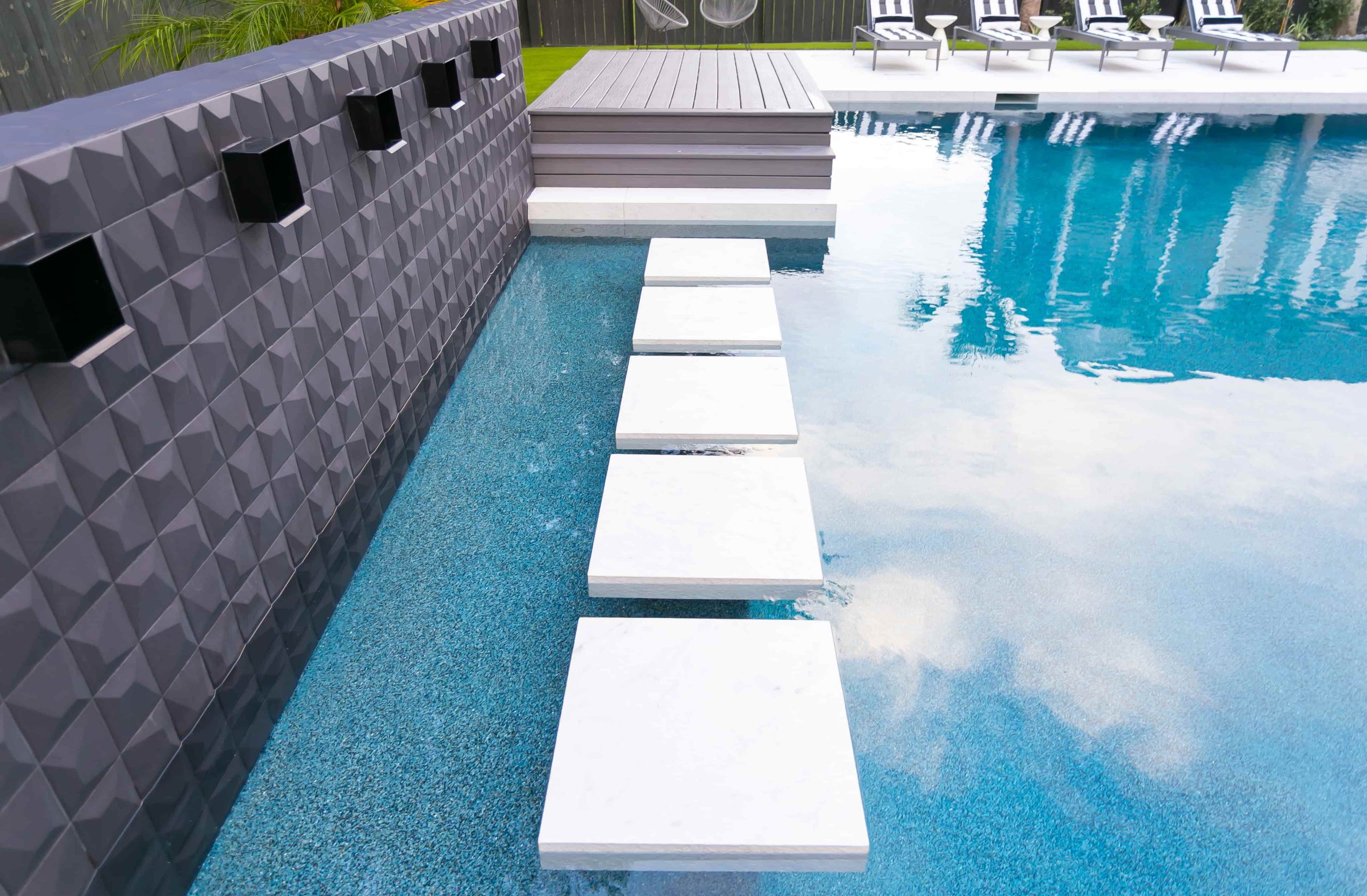 rectangular pool with modern floating step stones across shallow water