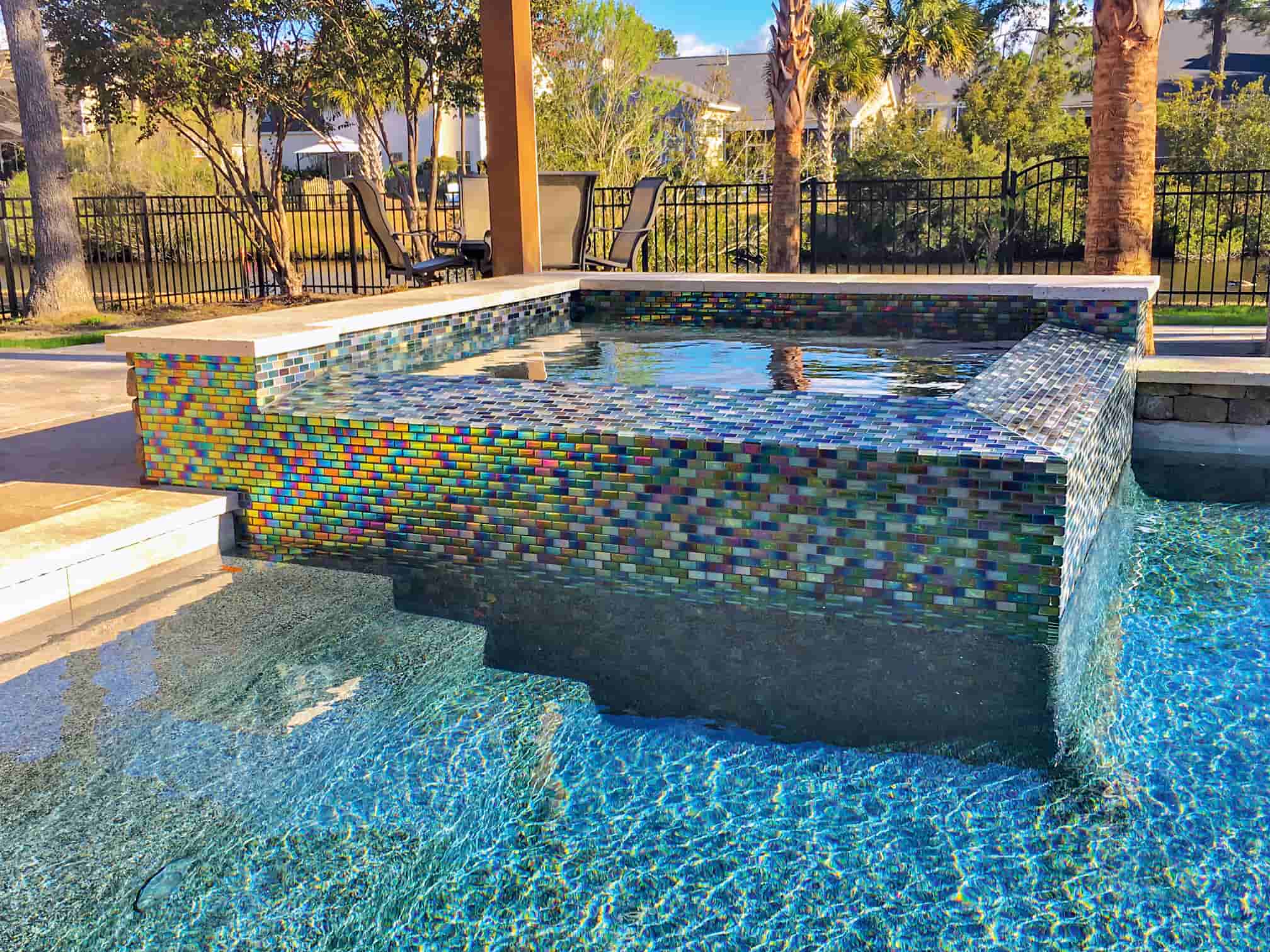 Raised gunite spa with custom iridescent glass mosaic tile finish