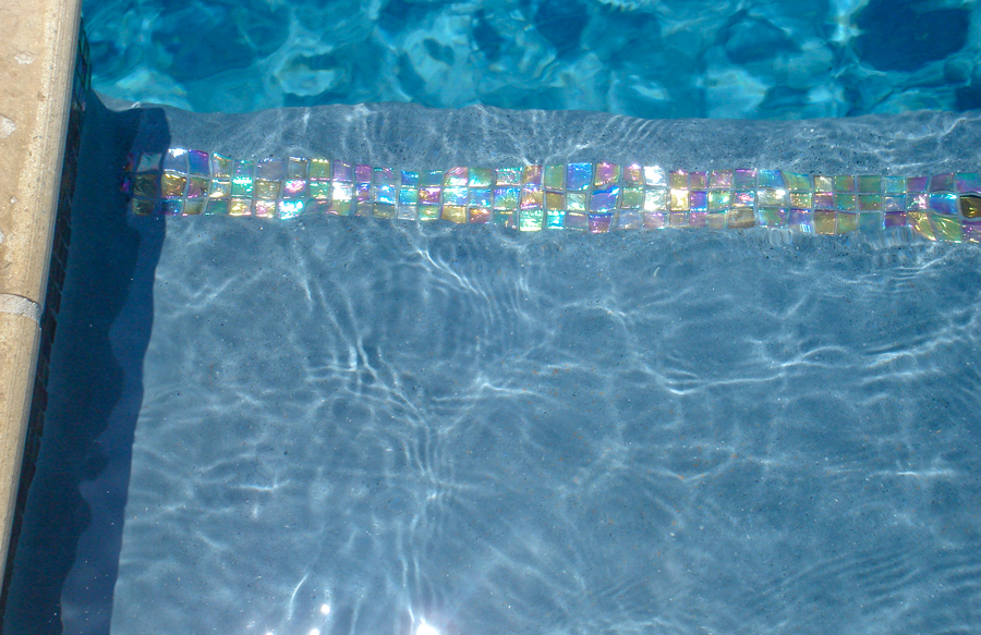 Iridescent glass tile on pool waterline