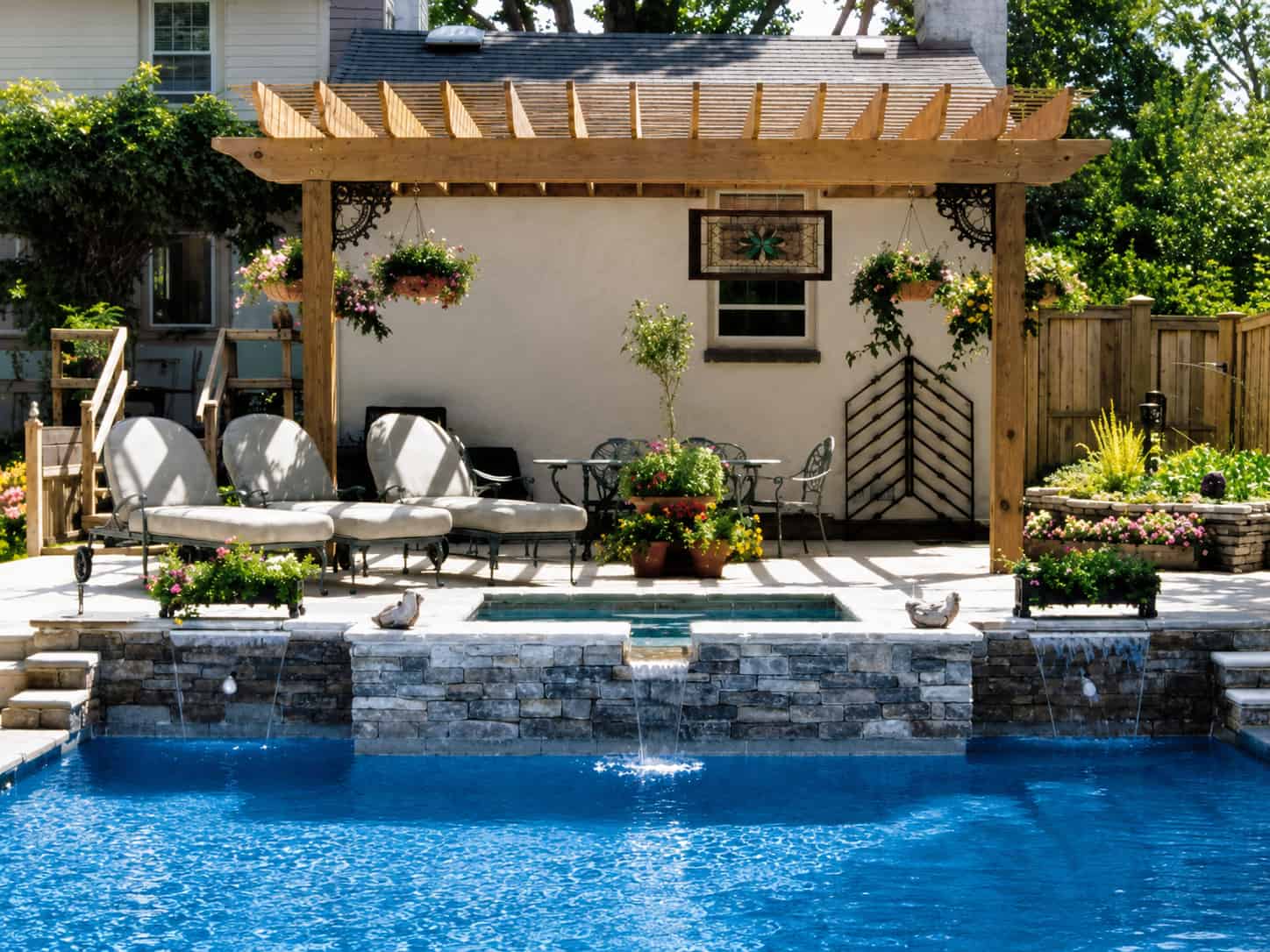 Wood pergola with hanging planters over a poolside patio and spa