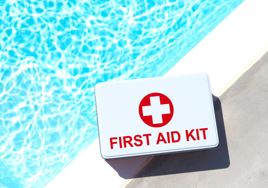 First aid kit sitting on a pool deck next to the water