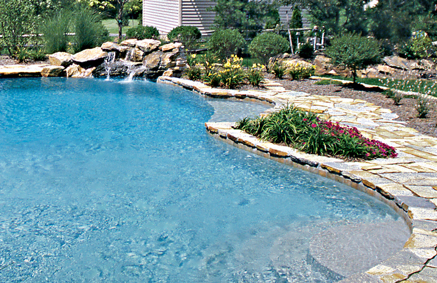 pool-with-rough-cut-stone-deck-and-waterfall