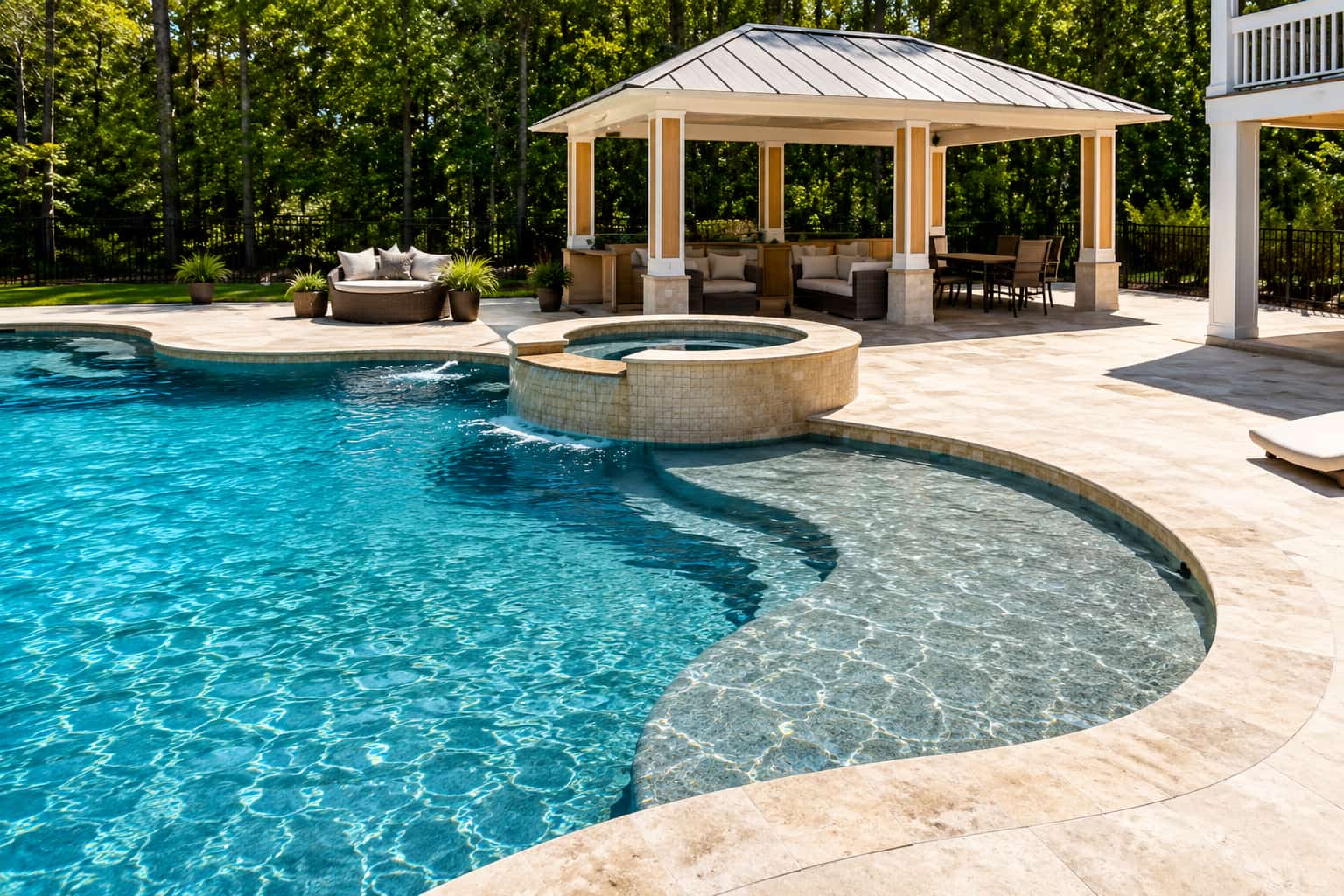 Backyard poolside pavilion with cushioned seating and stone columns
