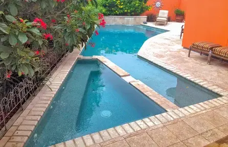 angular small backyard pool wrapping around patio for efficient space use