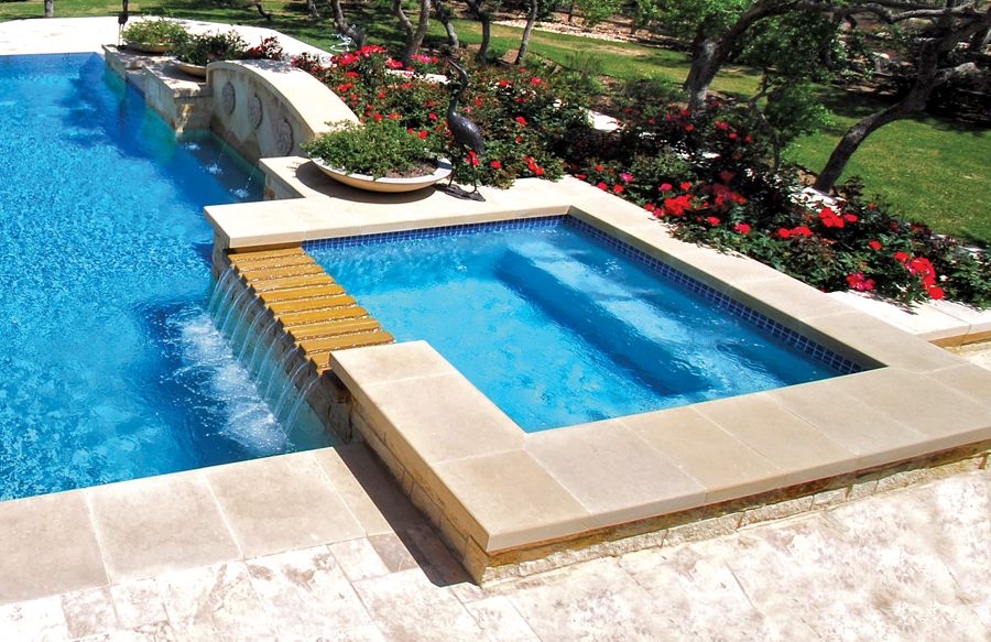 Raised spa with waterfall spillway into pool