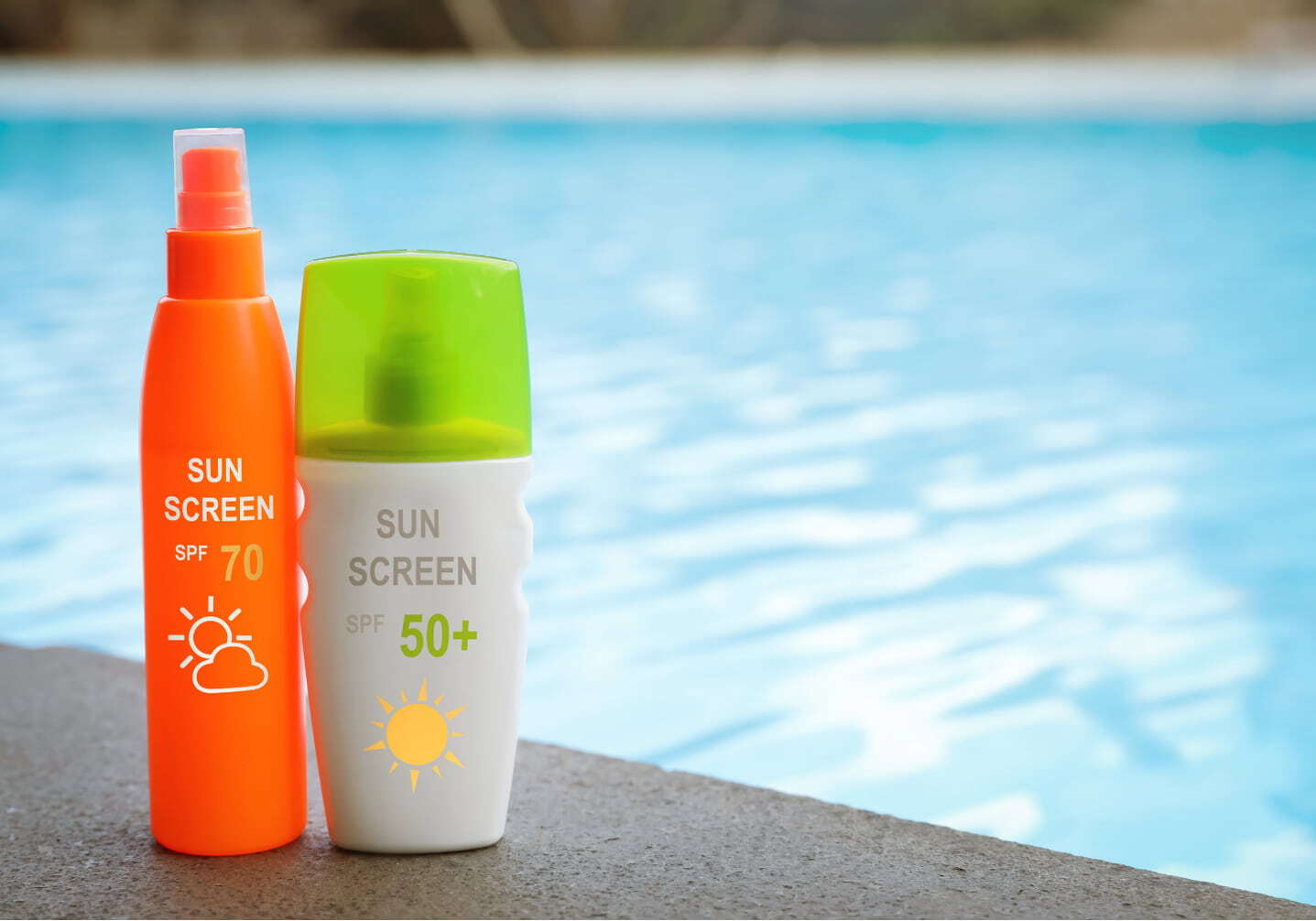 Two sunscreen bottles, SPF 70 spray and SPF 50 lotion, sitting at the edge of a backyard swimming pool