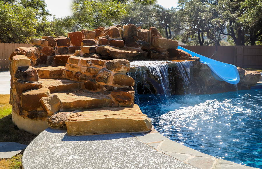 stairs-to-slide-on-rock-waterfall-on-gunite-pool