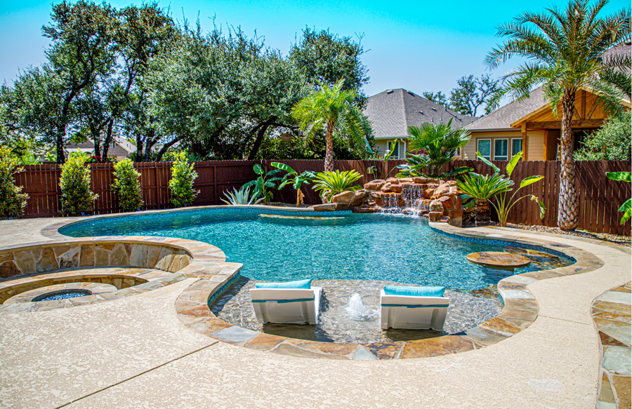 Tropical swimming pool with natural stone coping and freeform design